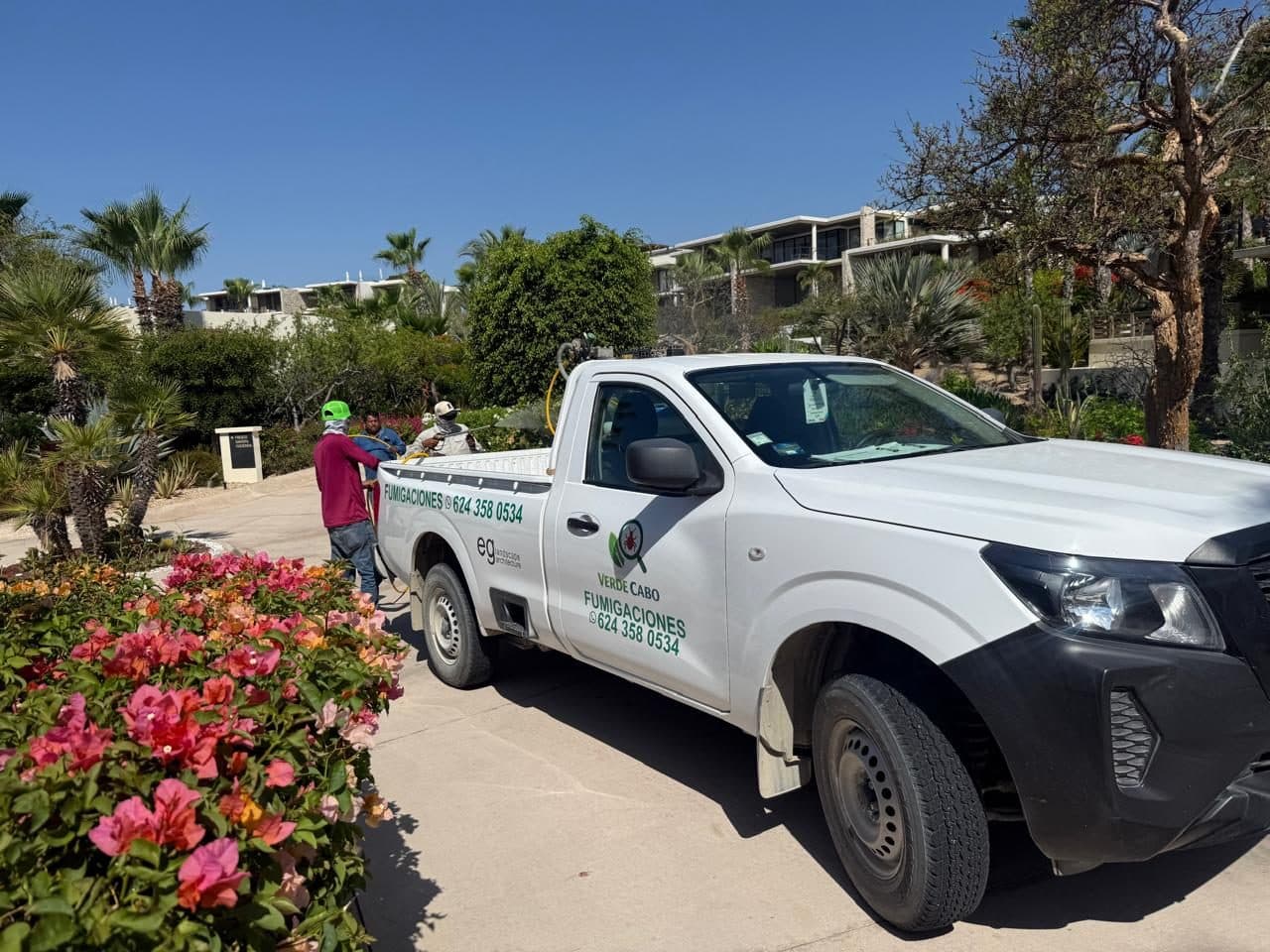 Unidad de Verde Cabo y cuadrilla junto a jardines con buganvilias en un desarrollo residencial